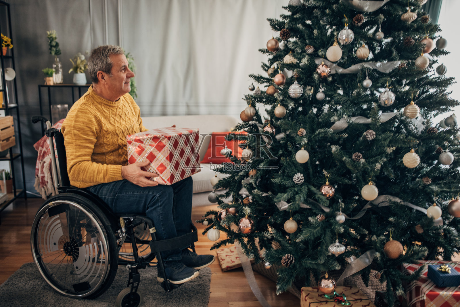 一位残疾老人在装饰圣诞树照片摄影图片