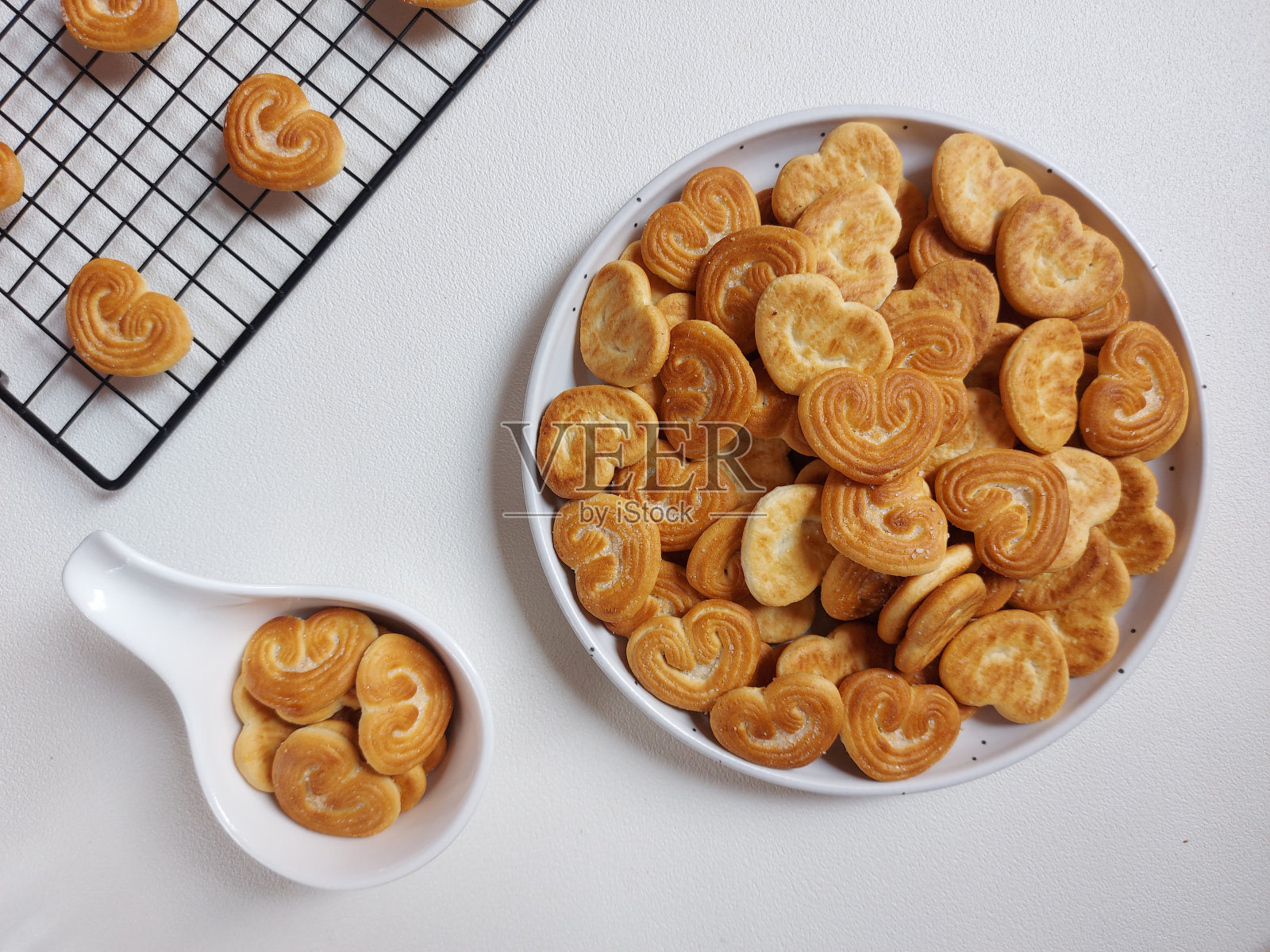 在饼干上撒糖，做成心形。照片摄影图片