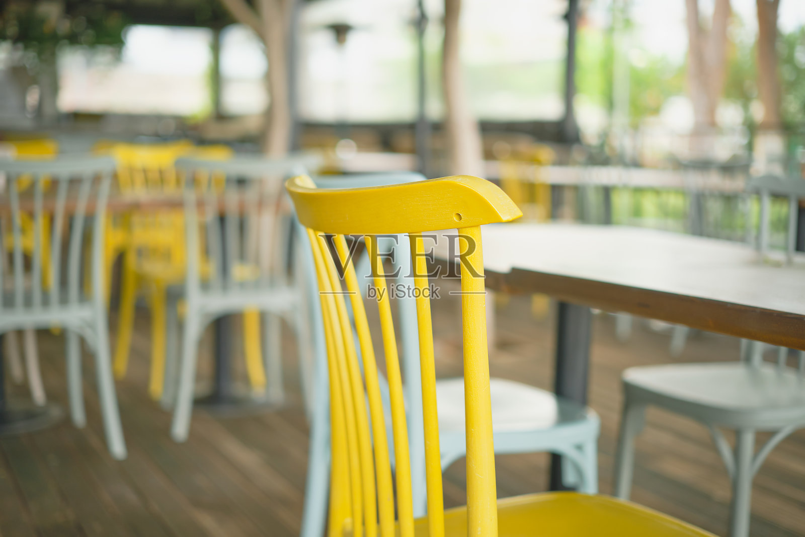 酒吧里的木椅特写。选择性地聚焦在一张黄色的椅子上。酒吧视图，焦点模糊，酒吧装饰的想法或照片为内部照片摄影图片
