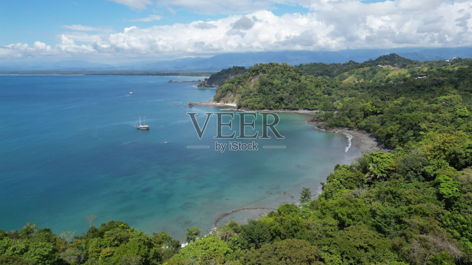 航拍到一艘白色的船在夏天驶向绿树之地照片摄影图片