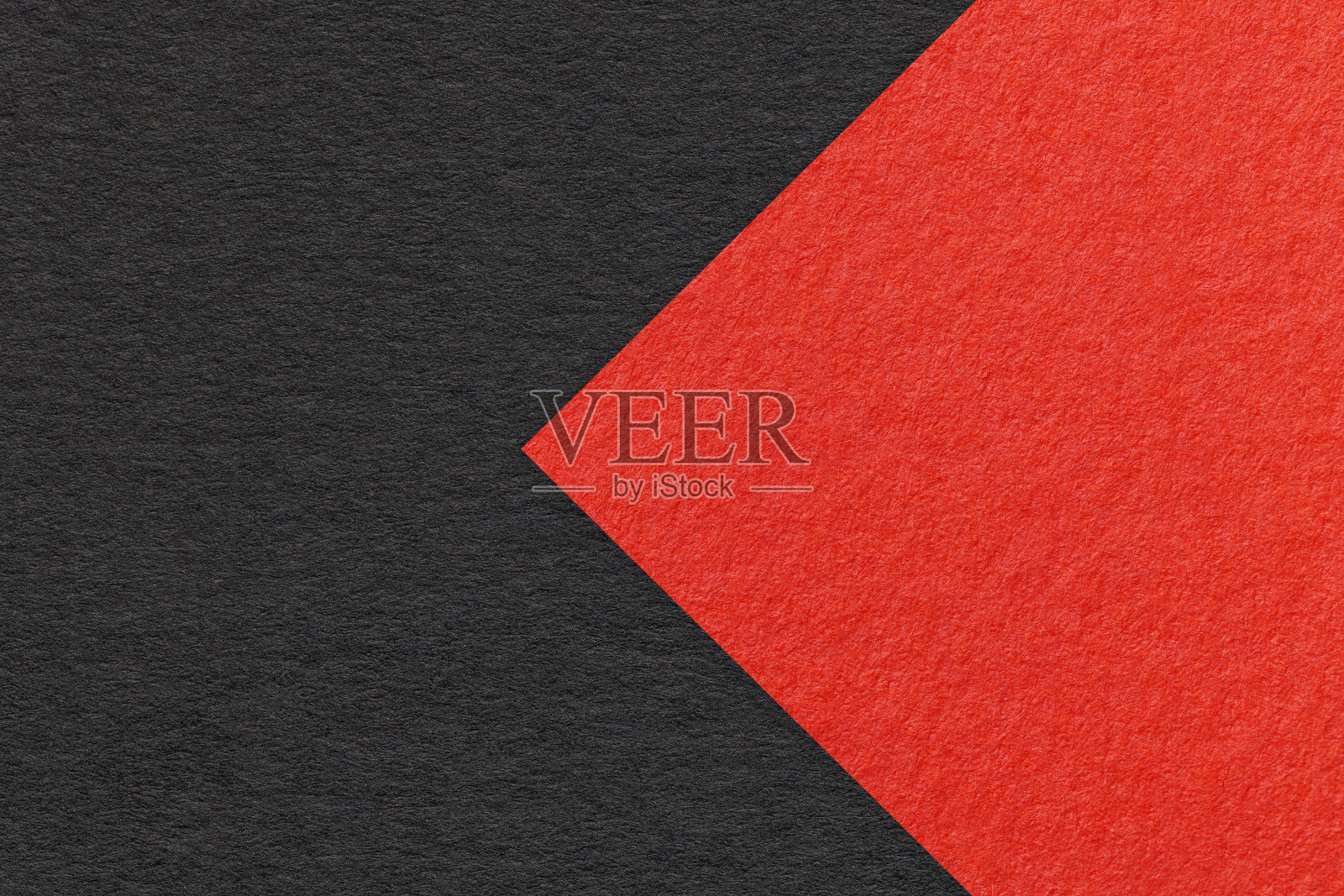 纹理为黑色纸背景，一半两色带红色箭头，微距。结构致密的工艺纸板。照片摄影图片