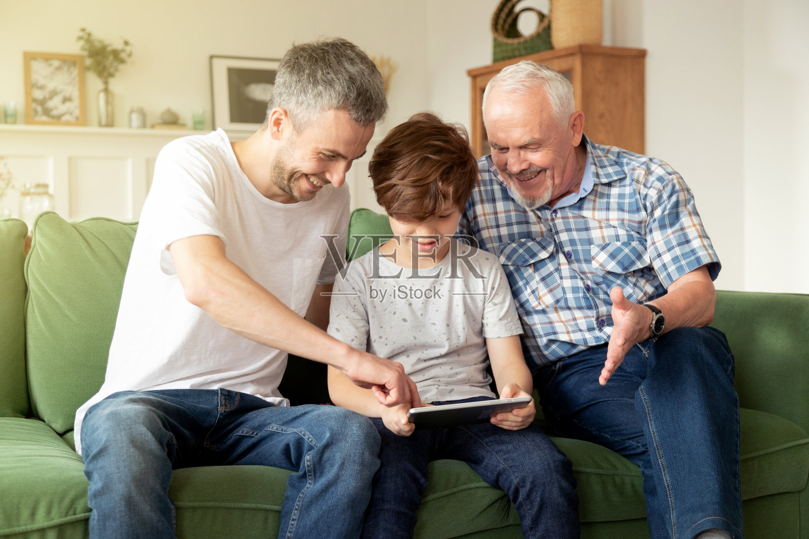 爷爷，成年的儿子和孙子一起在家里使用平板电脑照片摄影图片