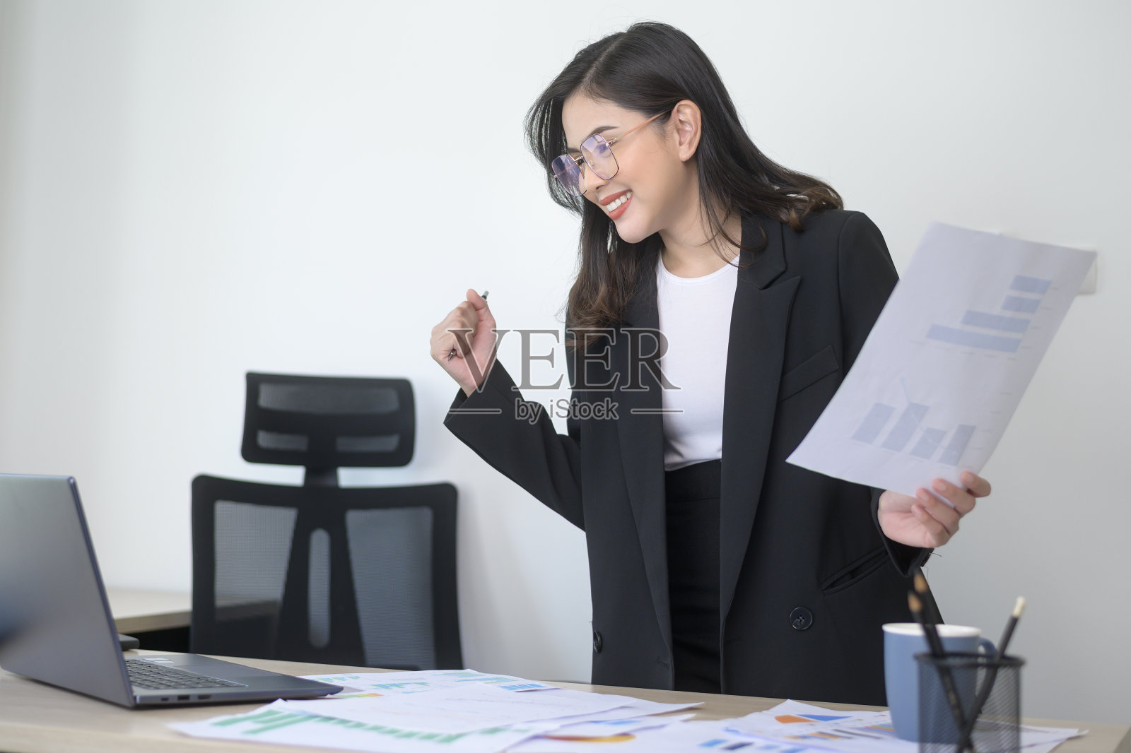 年轻美丽的女商人在笔记本电脑上工作，在现代办公室文件照片摄影图片