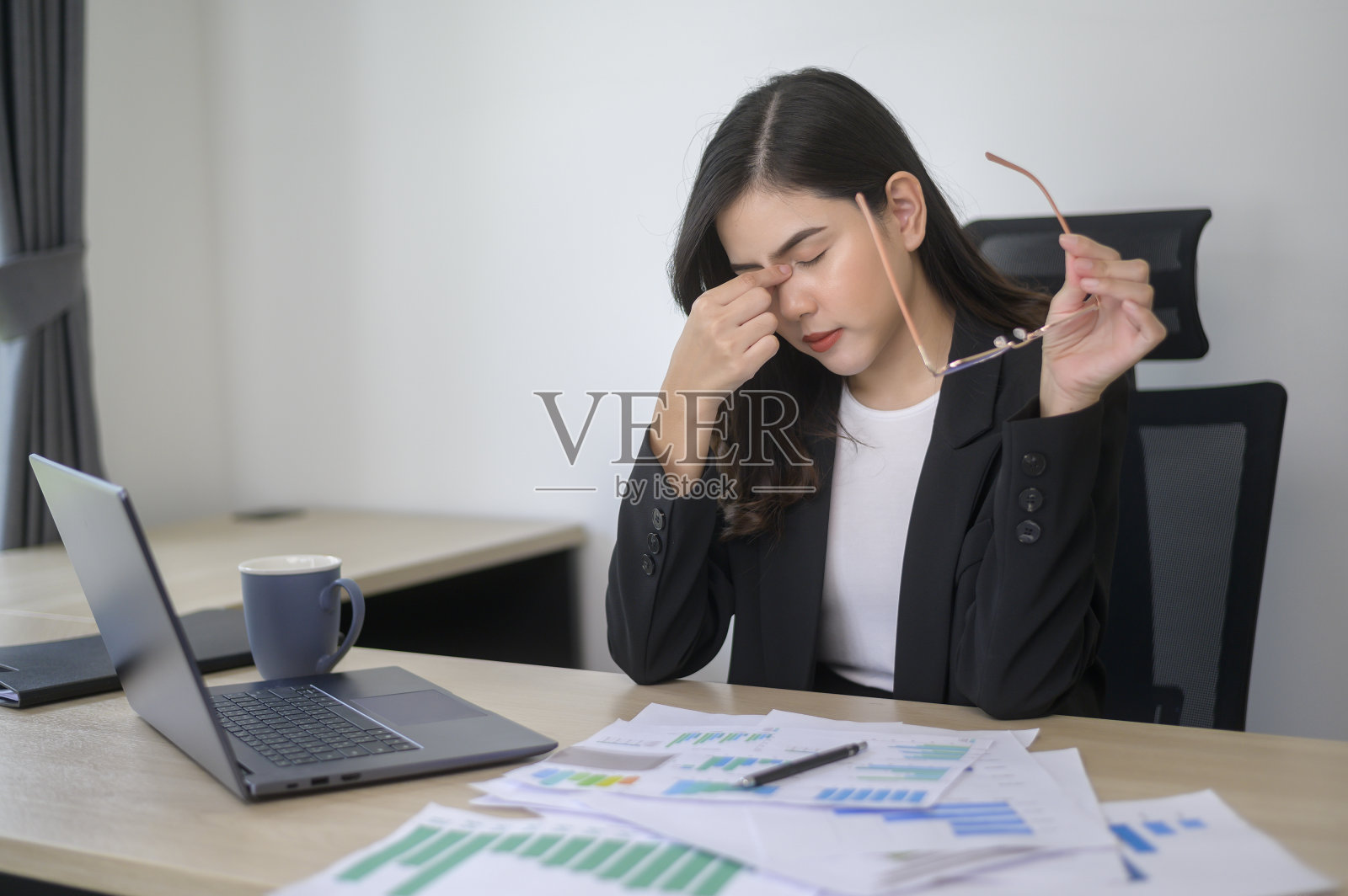 压力大的年轻商业女性在笔记本电脑上工作，在现代办公室，工作量概念照片摄影图片