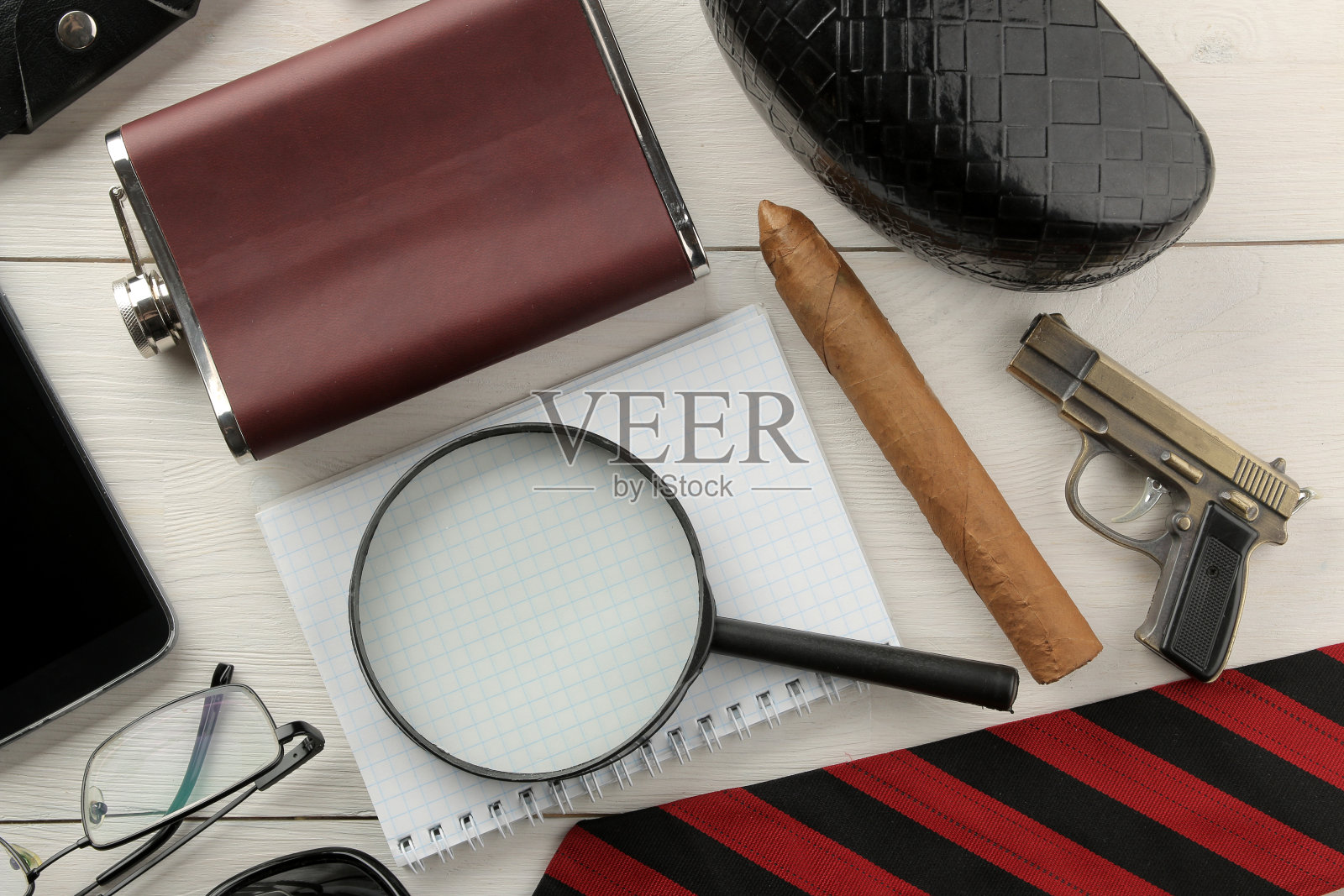 男人的配件。男人的风格。烧瓶，放大镜，笔记本，眼镜，领带，白色木制背景上的雪茄。平的。照片摄影图片