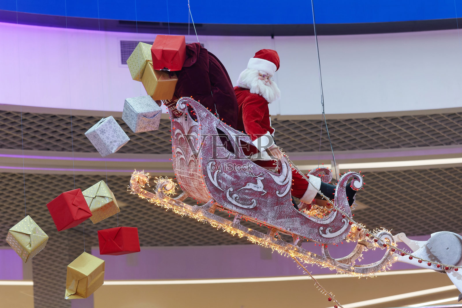 圣诞老人坐在雪橇上，礼物从雪橇上掉下来。圣诞节和新年的概念照片摄影图片