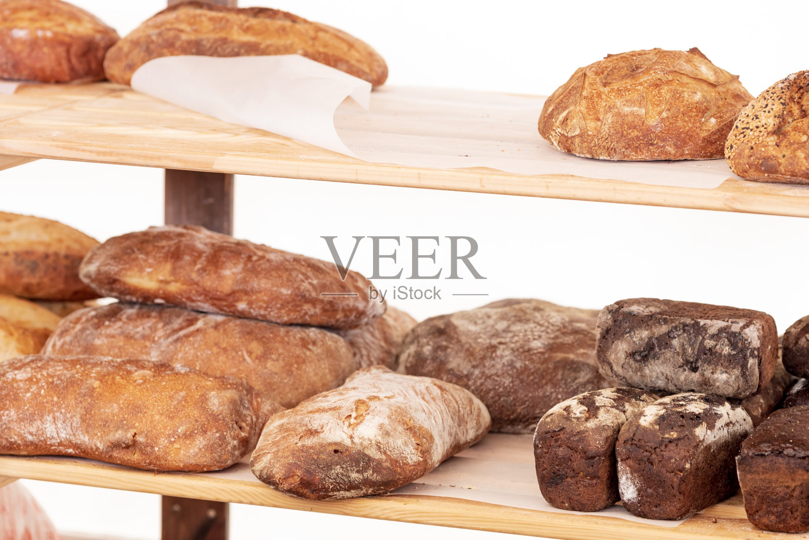 店里货架上新鲜的面包，背景是白色的照片摄影图片