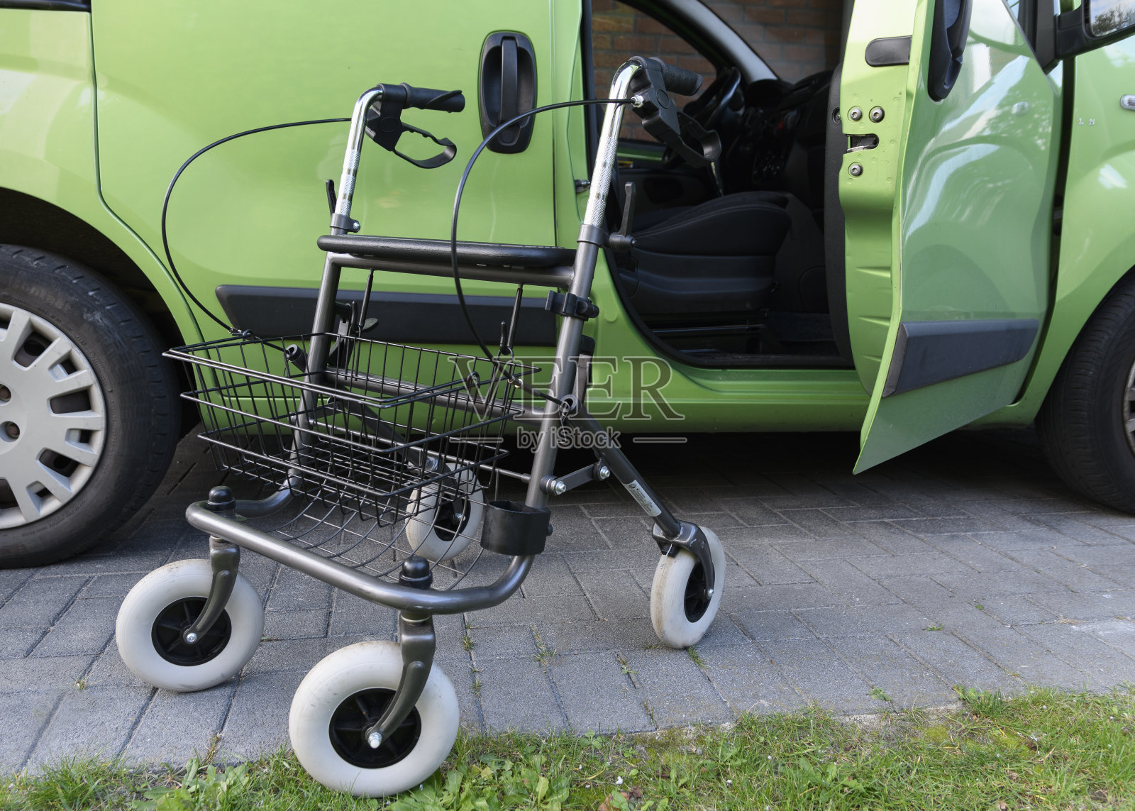 当被用于进入汽车的副驾驶座位时，滚轮助行器在外面照片摄影图片