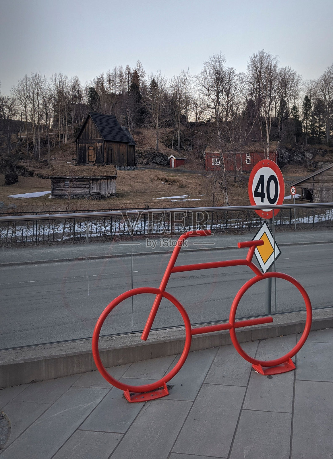 现代红色自行车雕像，背景是老房子和路标照片摄影图片