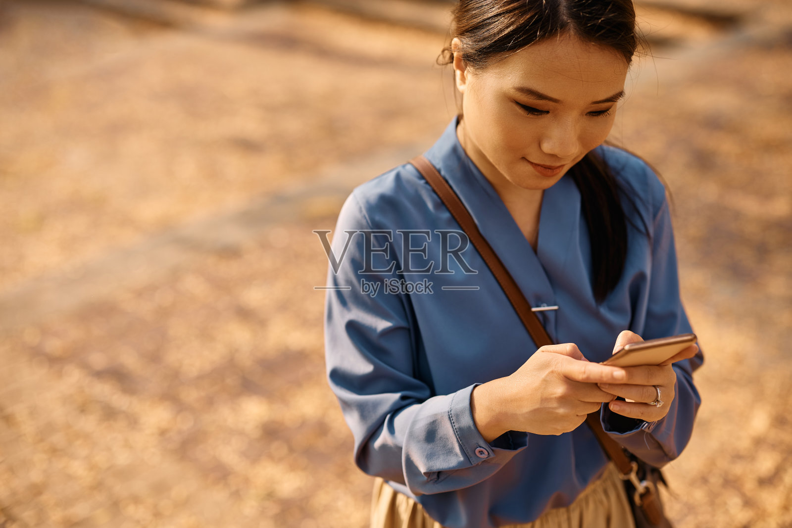 年轻的亚洲女商人在户外使用智能手机。照片摄影图片