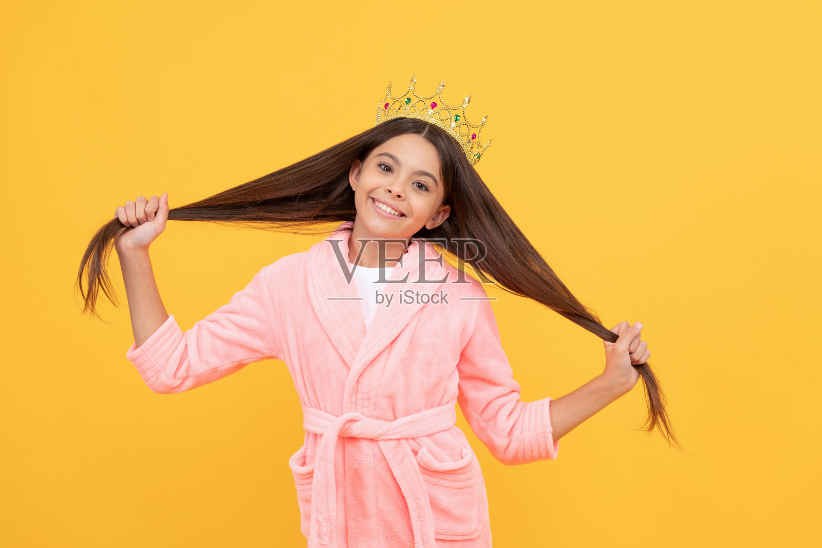 童年的幸福。美丽的公主有一头长发。自私的孩子戴着冠冕。照片摄影图片