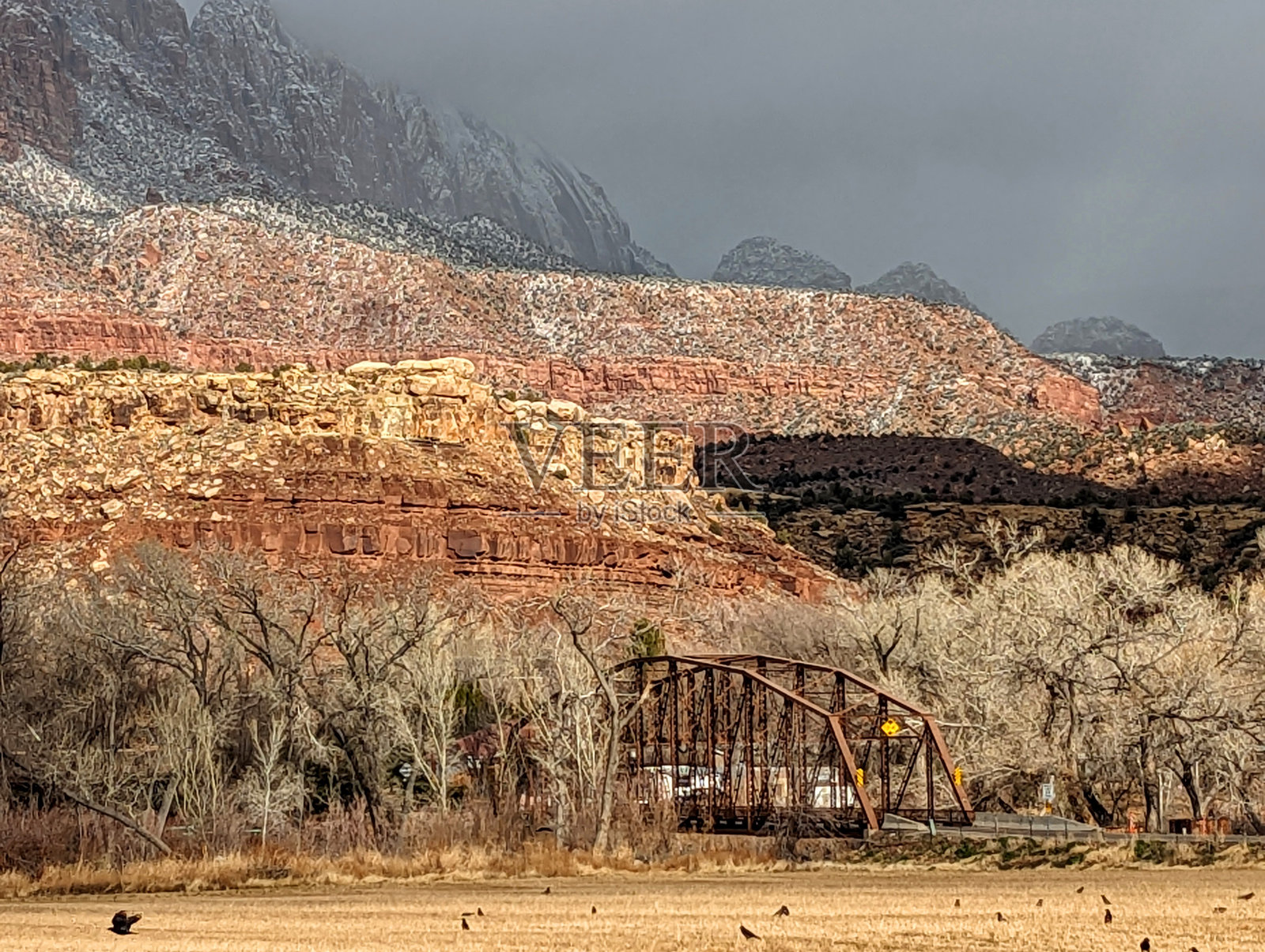 犹他州锡安国家公园附近的维珍河谷上，历史悠久的罗克维尔桥上有新的雪和云景照片摄影图片