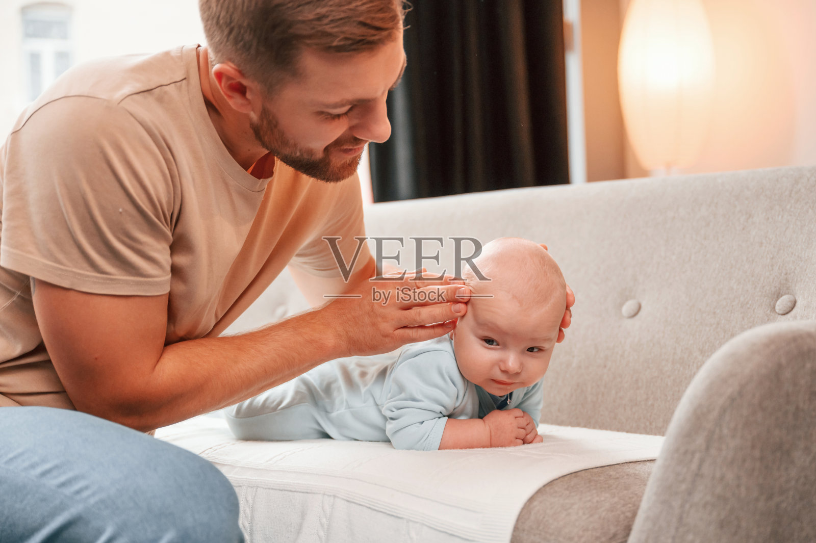 刚出生的婴儿躺在沙发上。人在室内。单身爸爸的概念照片摄影图片