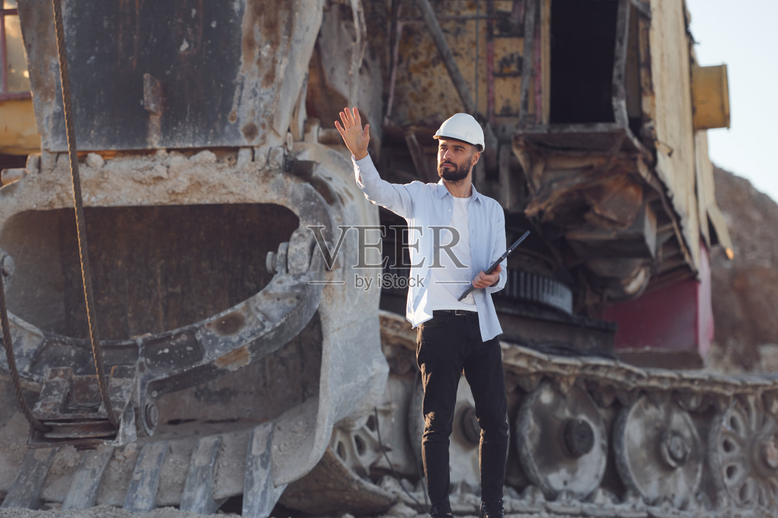 与笔记本电脑。穿制服的人白天在采石场工作照片摄影图片