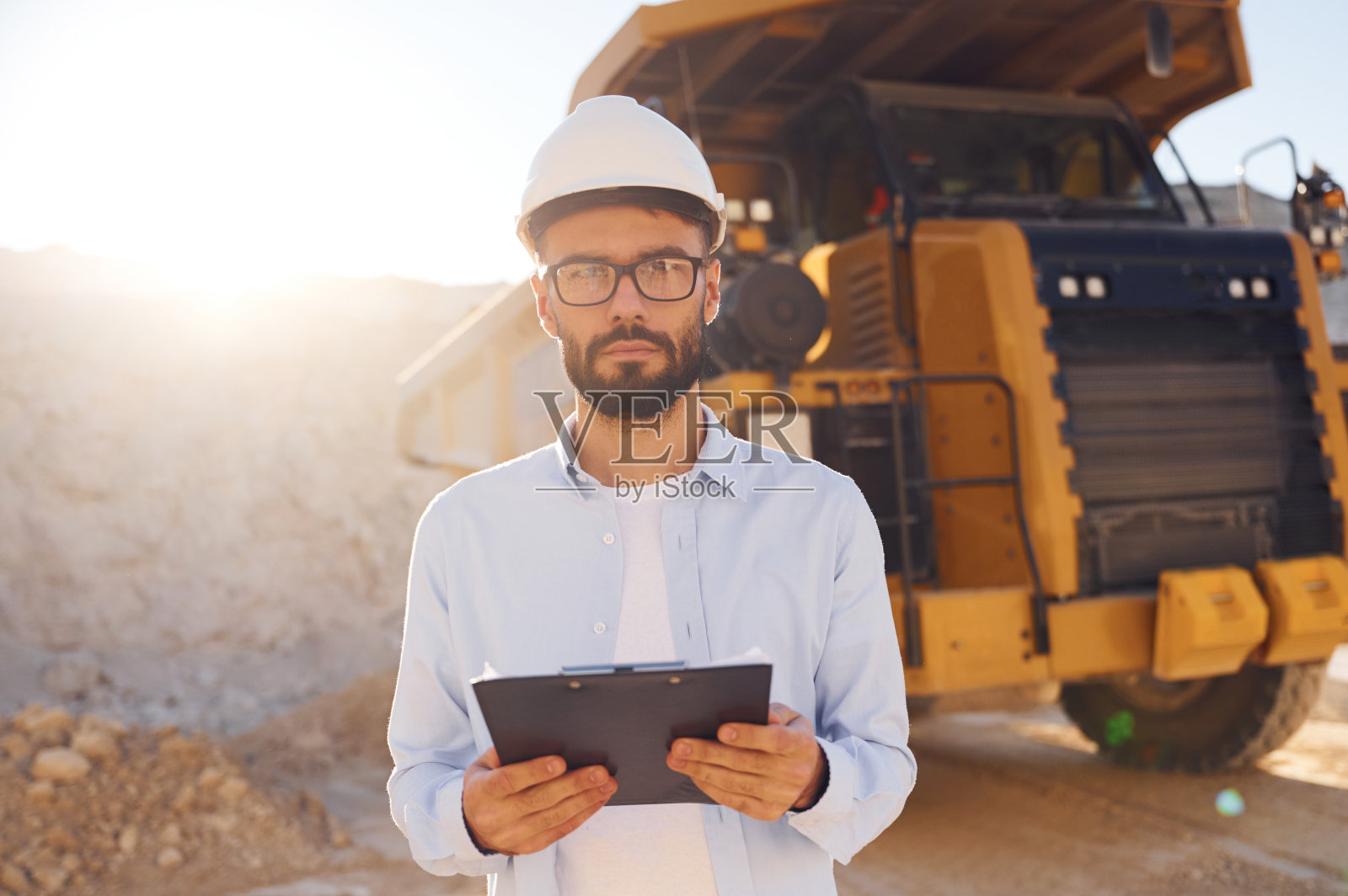 戴安全帽、眼镜和笔记本。穿制服的人白天在采石场工作照片摄影图片