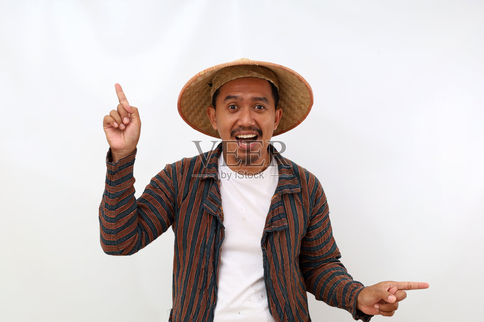 快乐的亚洲农民站着，指着两边。白色背景隔离照片摄影图片