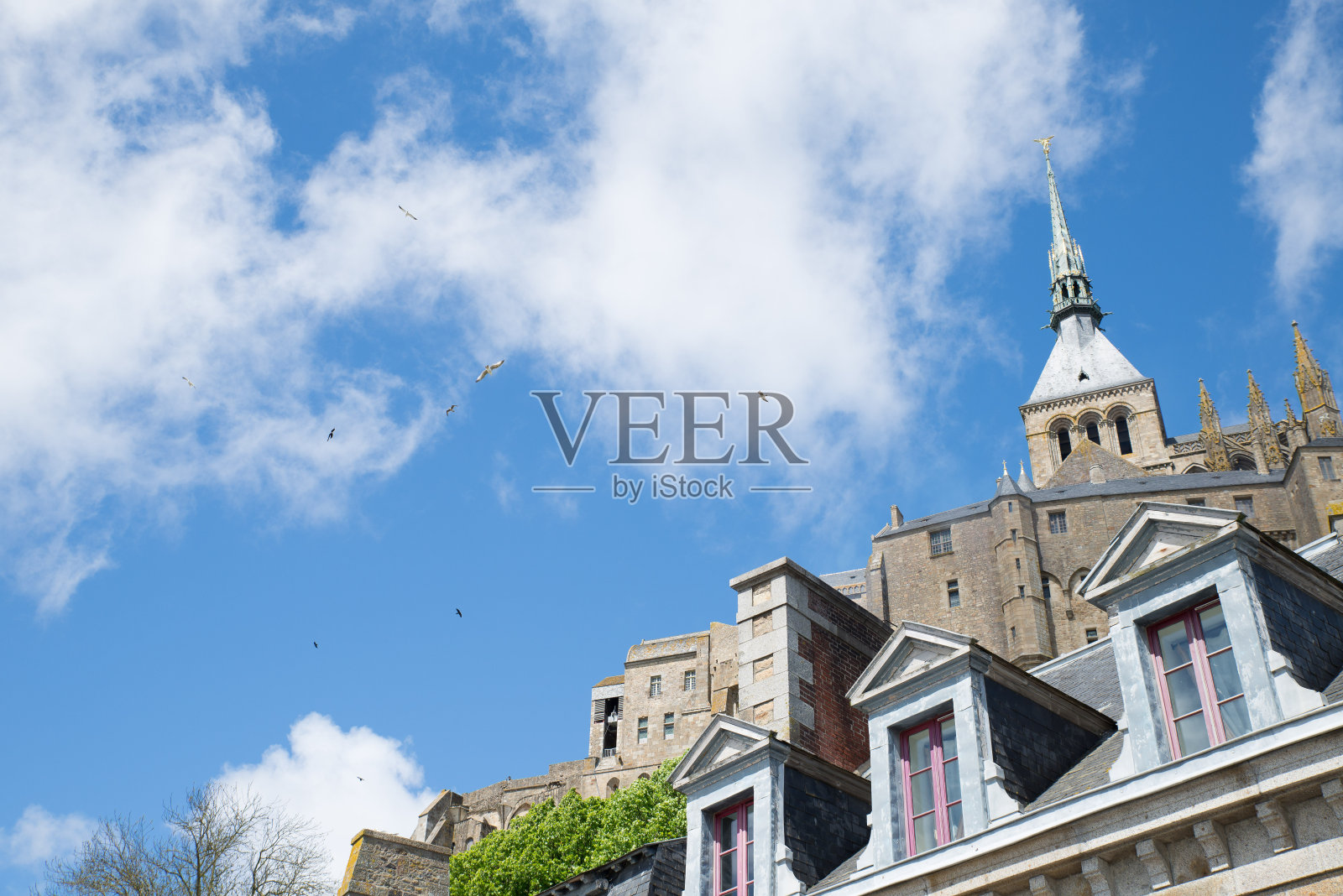 底部拍摄的一些建筑物在一个多云的天空背景在圣米歇尔山。照片摄影图片