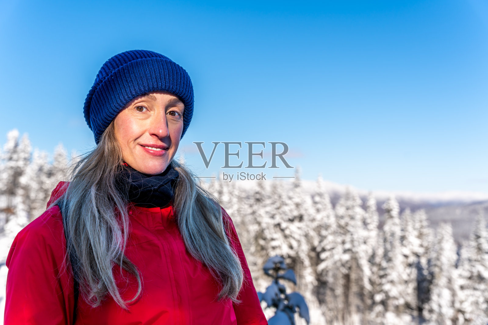 魁北克省一座雪山上的女子肖像。照片摄影图片