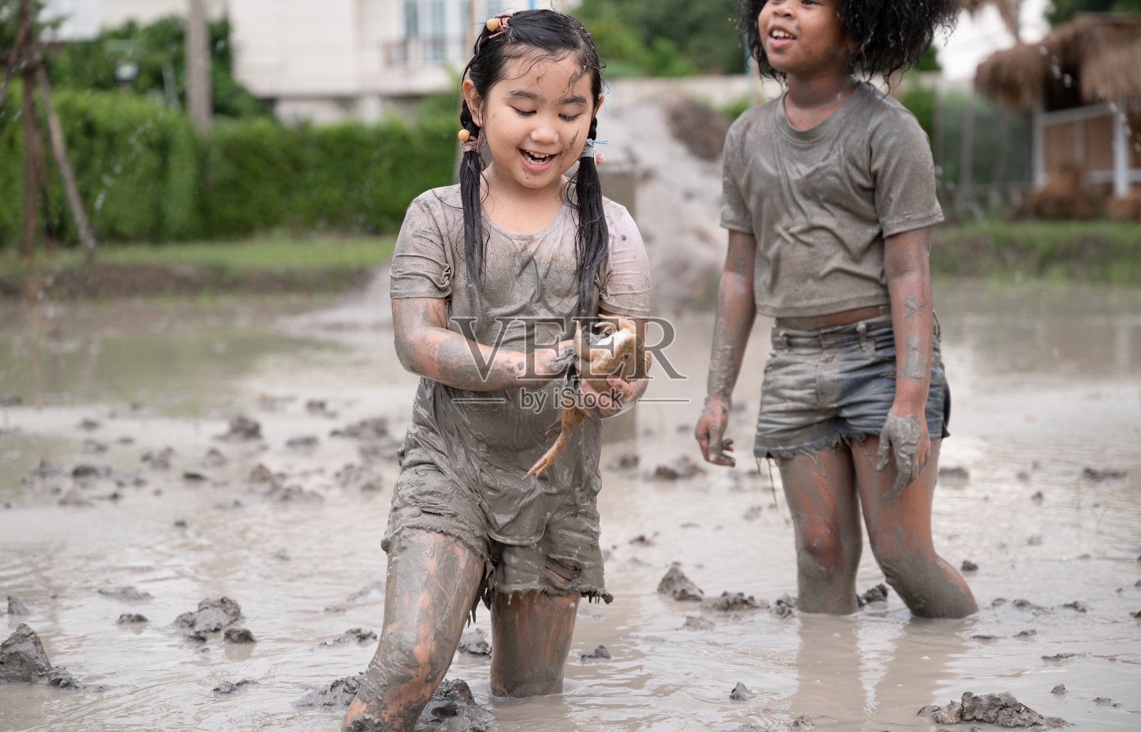 有趣的亚洲孩子女孩拿着雾玩泥坑照片摄影图片