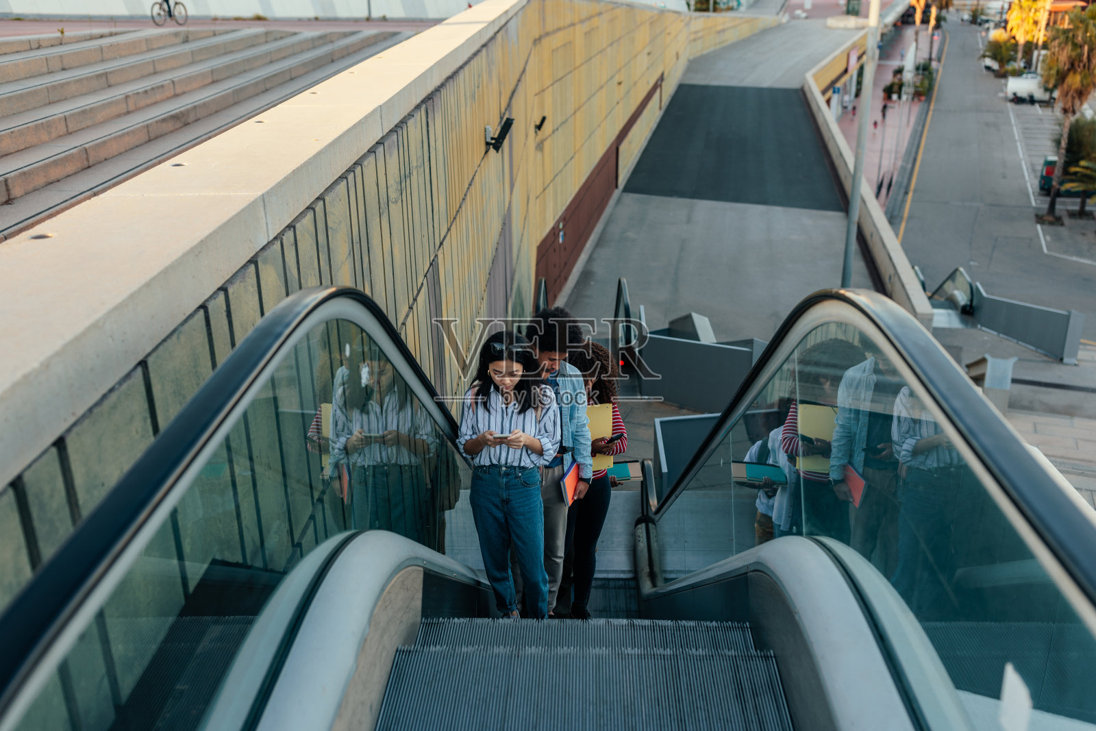 学生在城市使用自动扶梯。照片摄影图片