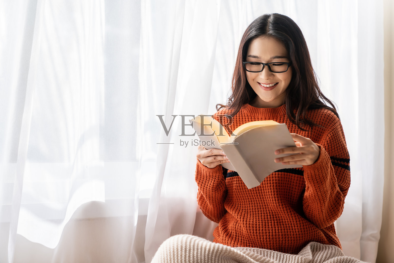 年轻的书呆子眼镜亚洲女人的肖像抱书在卧室。微笑快乐亚洲女孩知识教育大学女子亚洲冬季生活方式，回到学校，冠状病毒隔离概念照片摄影图片