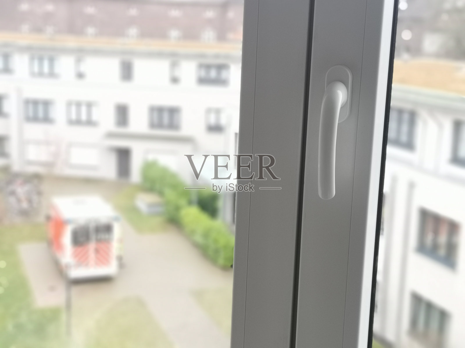 救护车停在小区的院子里，透过窗户照片摄影图片