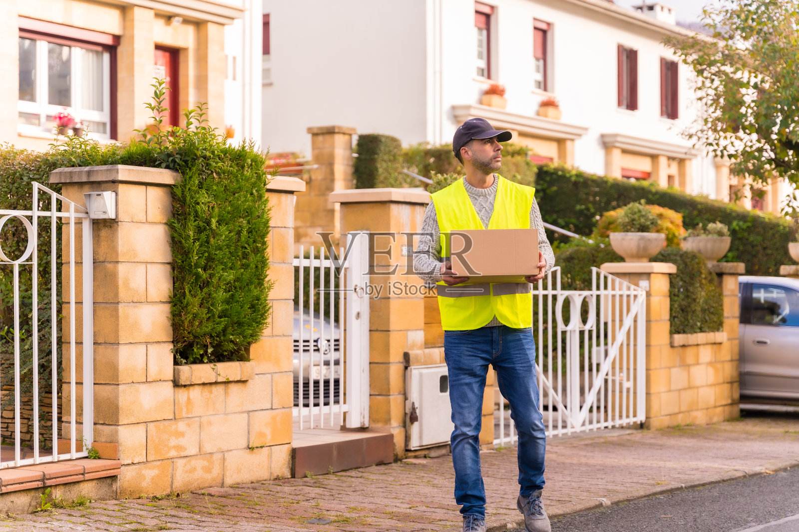 网上商店的包裹递送司机，在一些家庭手里拿着一个盒子照片摄影图片