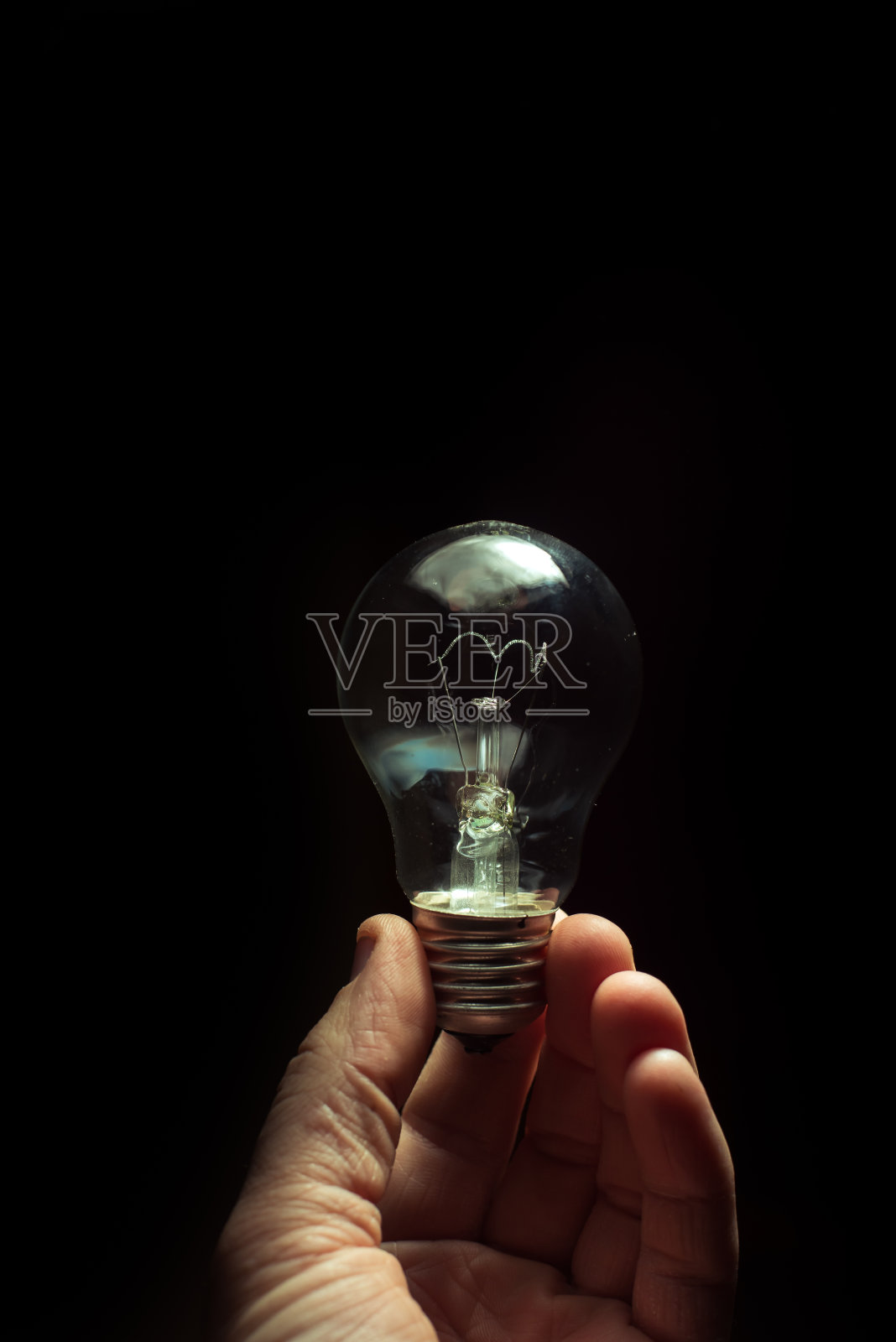 男人手里拿着灯泡照片摄影图片