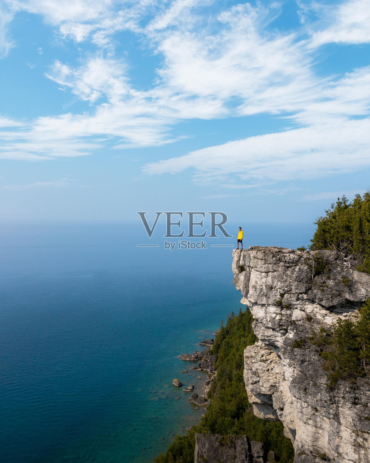 垂直航拍的一个人在山顶上看着大海照片摄影图片