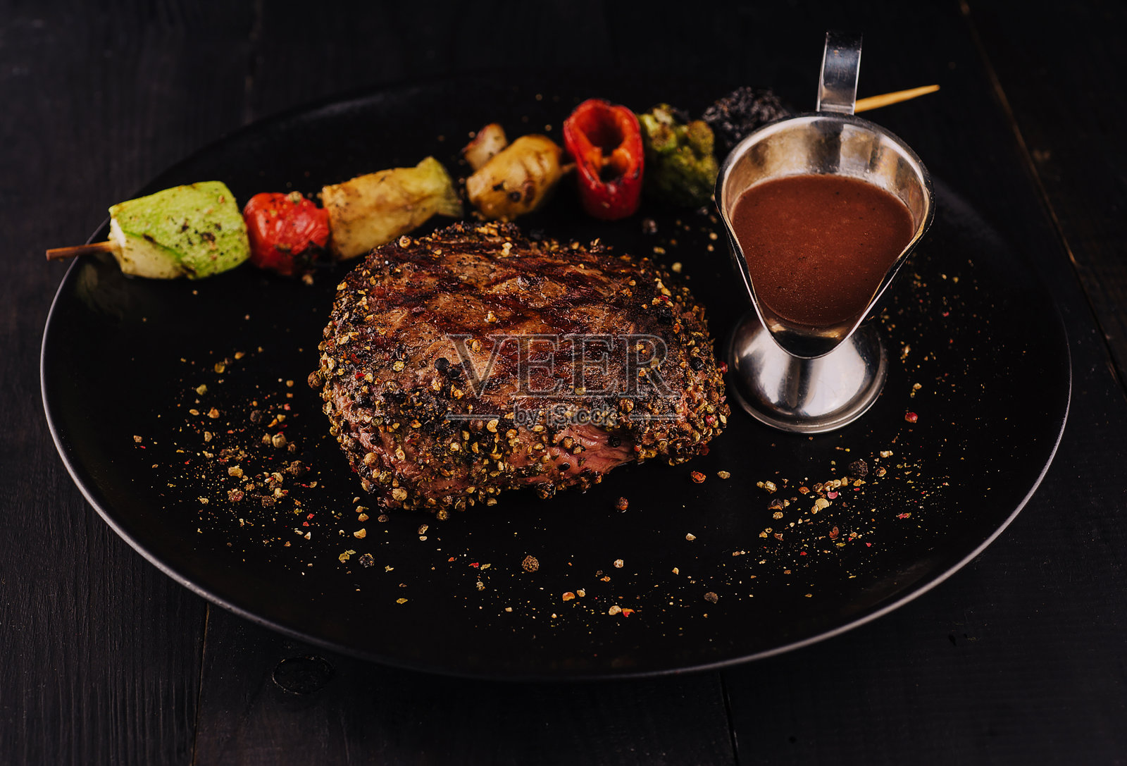 黑盘小牛排配烤蔬菜照片摄影图片