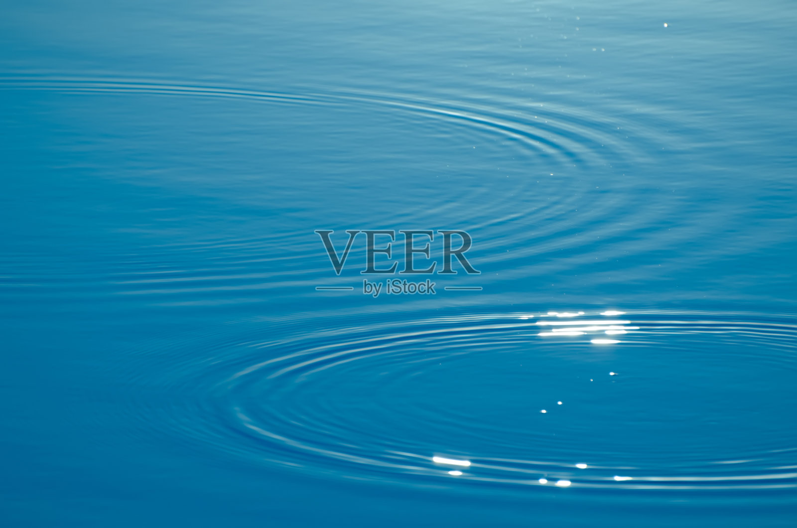 波浪在湖面上荡漾成圈。模糊透明的蓝色颜色清晰平静的水面纹理。潮流抽象自然背景与复制空间照片摄影图片