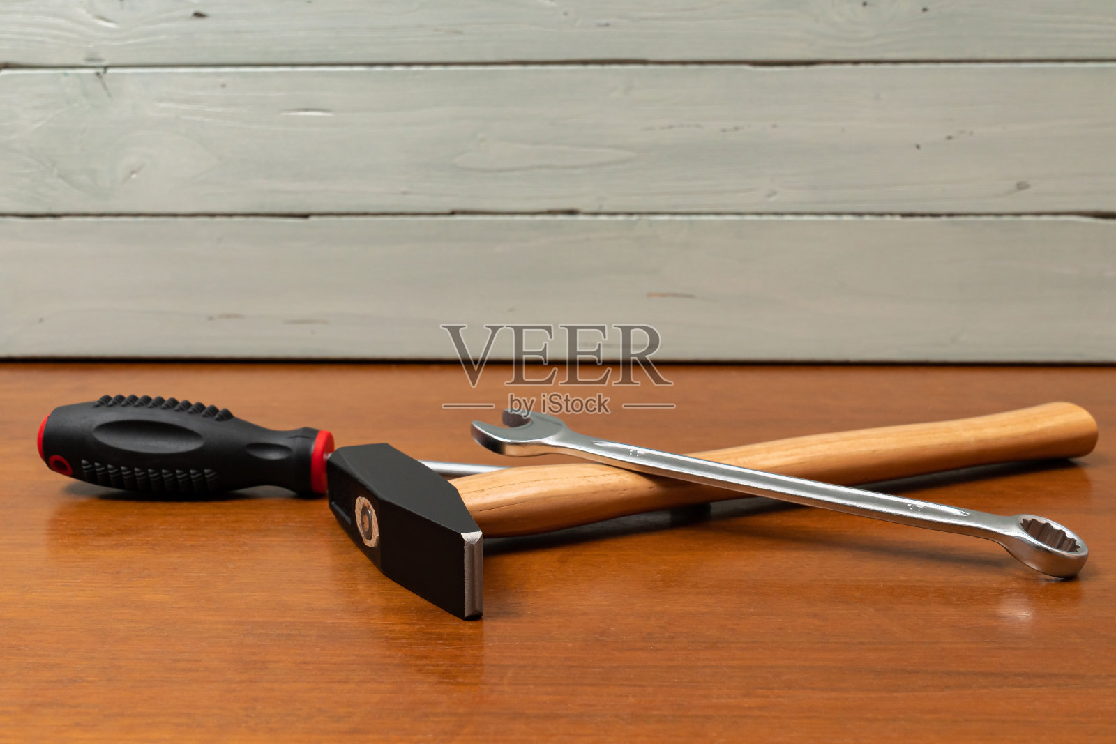 锤子、螺丝刀和扳手放在桌子上。照片摄影图片