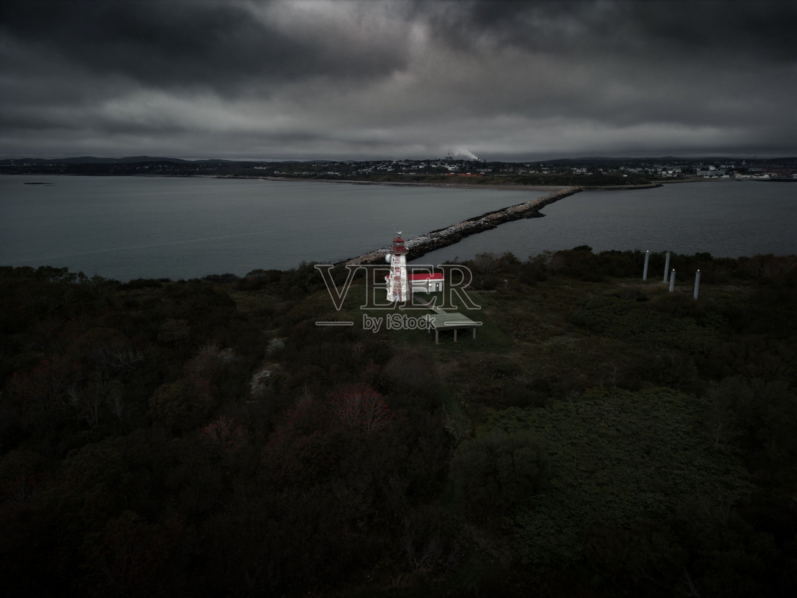 无人机拍摄的灯塔在自然领域与大海和码头在背景下多云的天空照片摄影图片