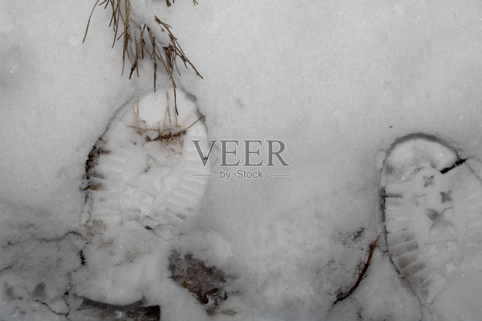 从鞋子上拍下雪地上的人类脚印照片摄影图片