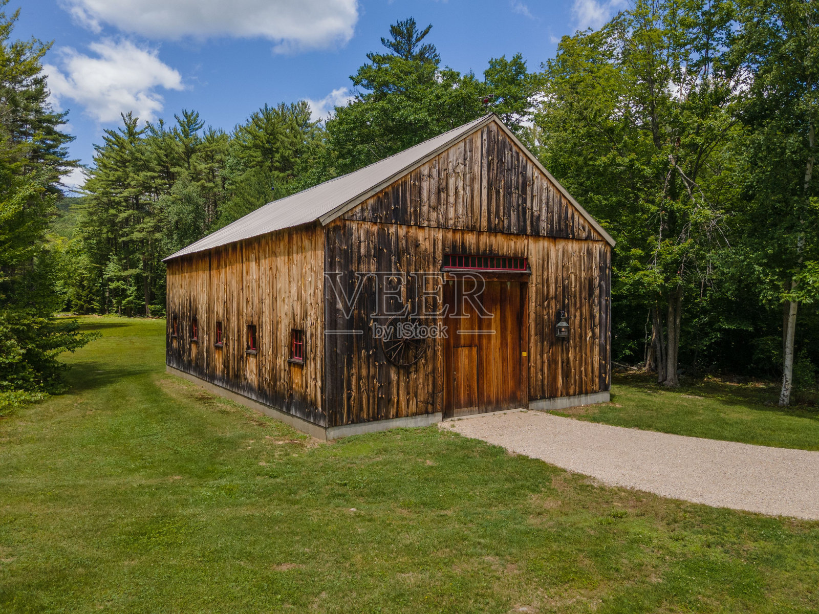 乡村小屋在白天被绿色植物包围，蓝天白云照片摄影图片