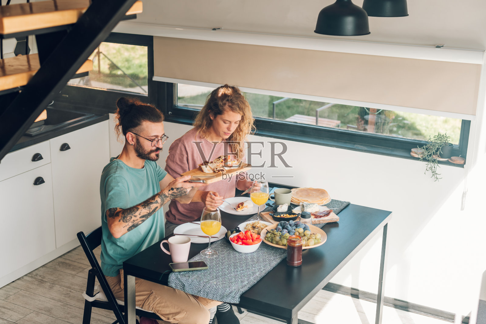 一对夫妇坐在家里的桌子旁一起吃早餐照片摄影图片