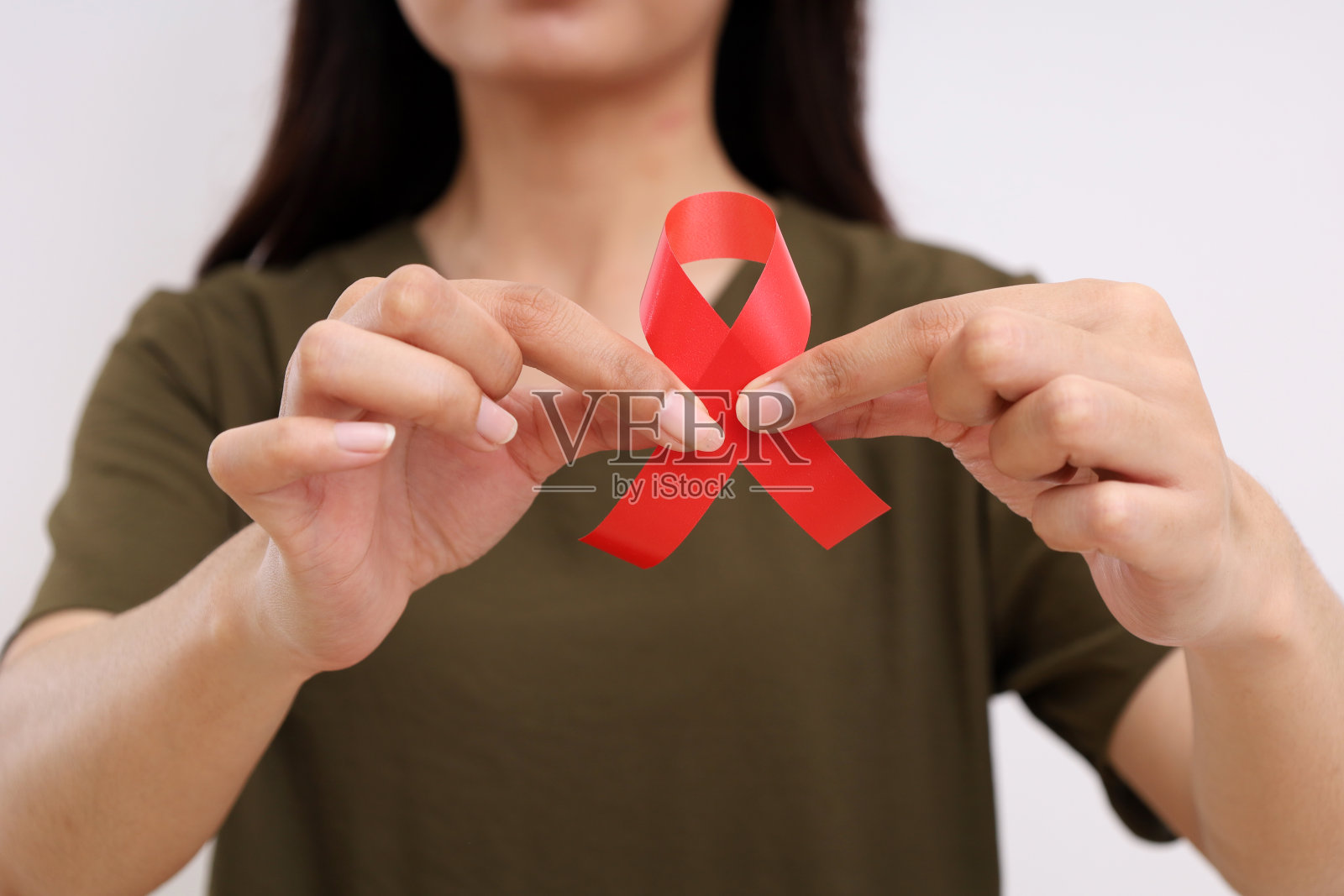 女人手拿红丝带的特写。艾滋病运动概念。与复制空间隔离照片摄影图片