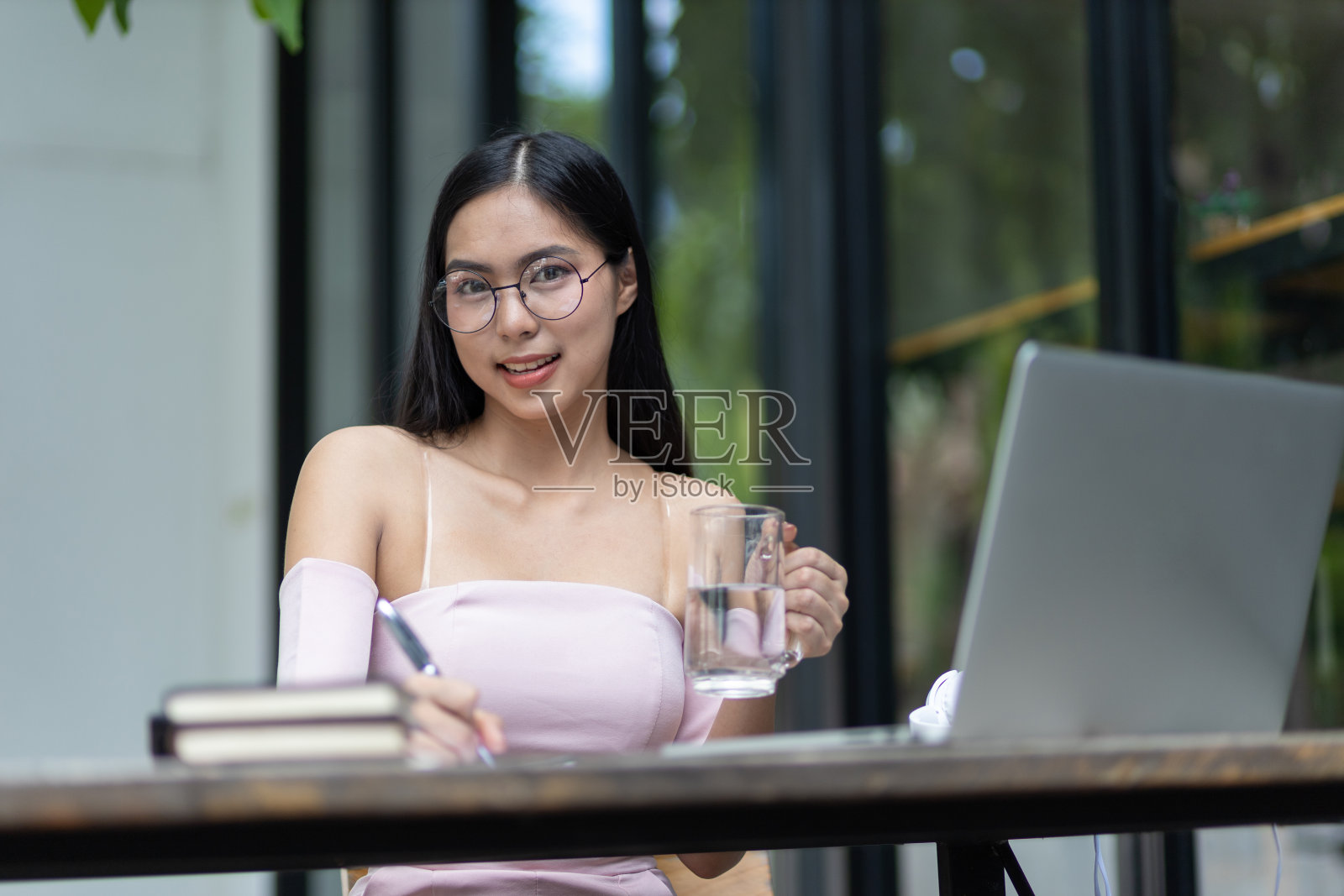 一个迷人又幽默的亚洲女人正在后院用笔记本电脑工作。在家工作。照片摄影图片