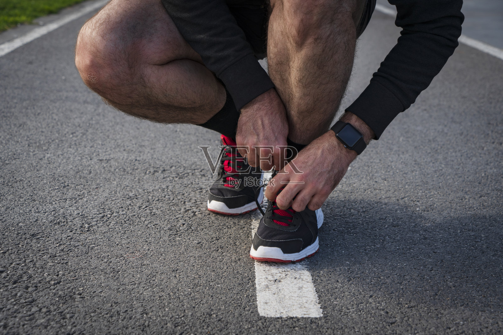 男子在锻炼时系鞋带照片摄影图片