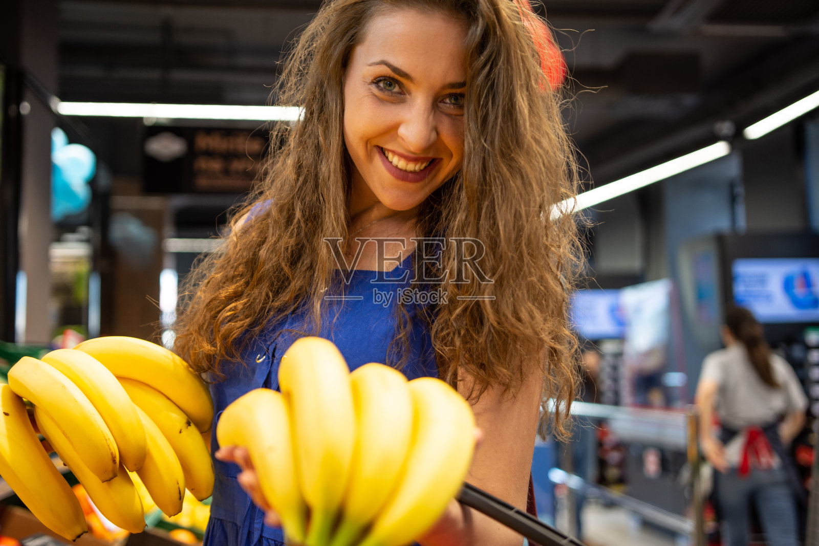 一个快乐微笑的年轻女子在超市购物照片摄影图片