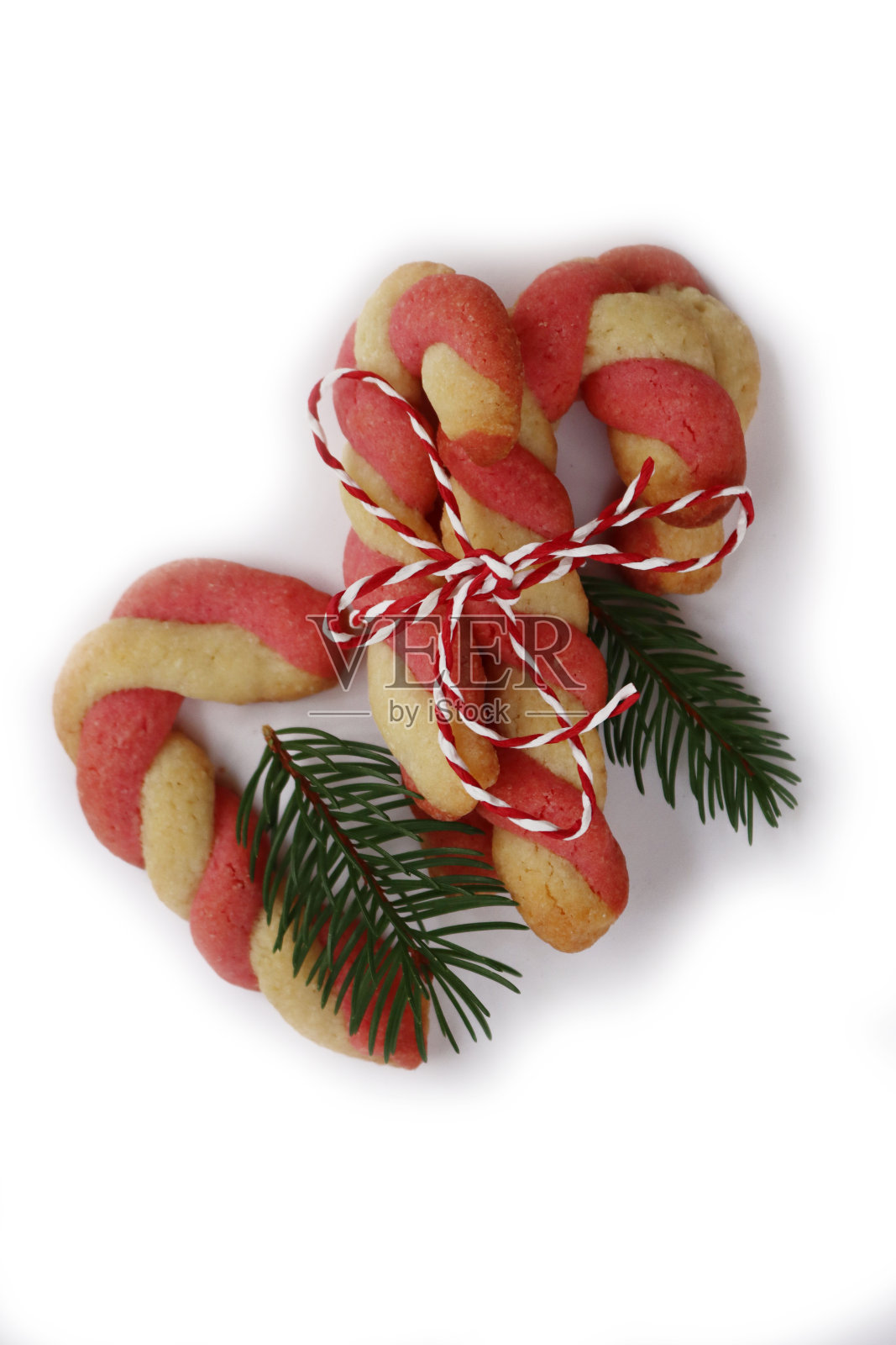 白色松枝装饰的拐杖糖形状的圣诞饼干照片摄影图片