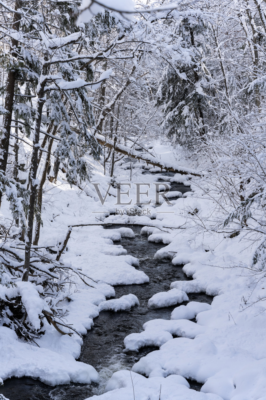 小溪与雪覆盖的岩石两边在切尔西，魁北克照片摄影图片