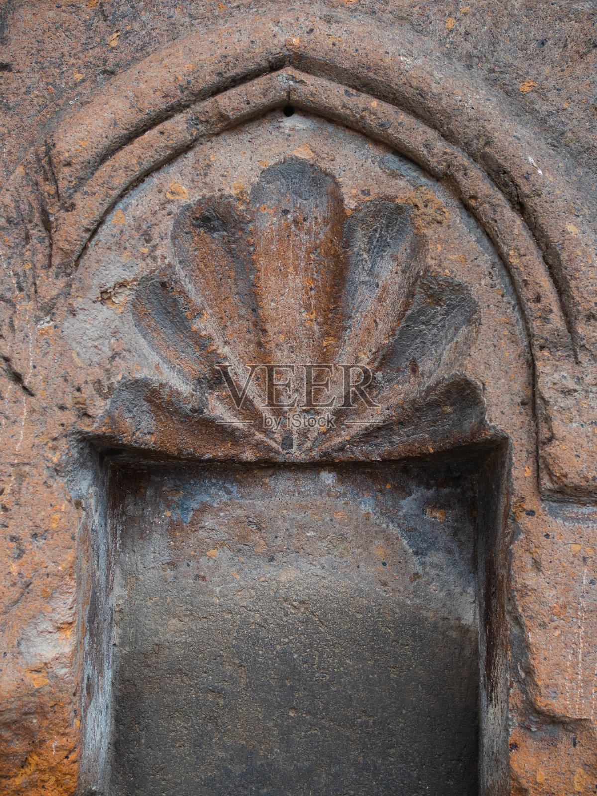 由亚美尼亚红色凝灰岩制成的古代砖石。有一扇漂亮的柳叶刀窗，照片摄影图片