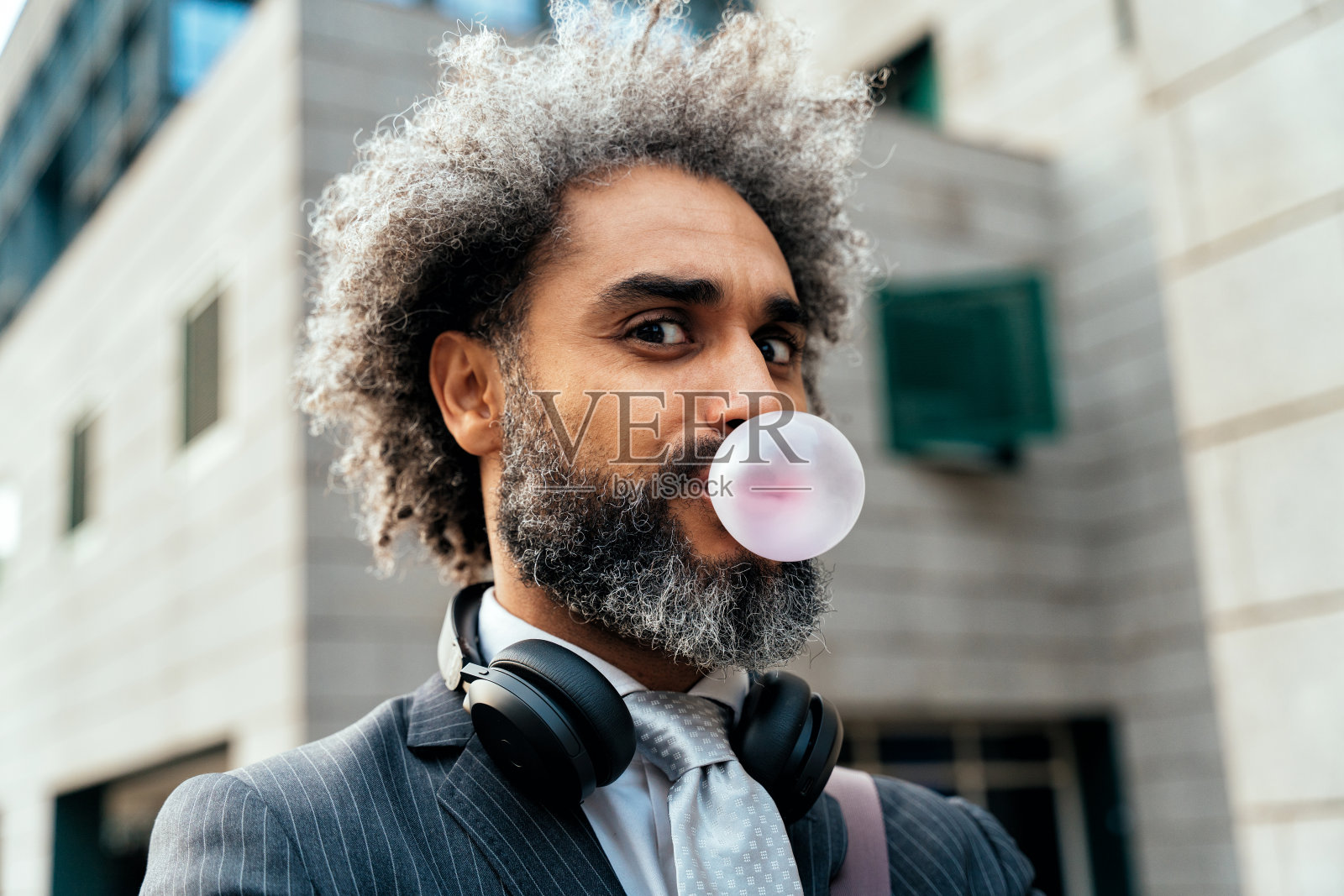 年轻的企业家嚼着水果泡泡糖照片摄影图片