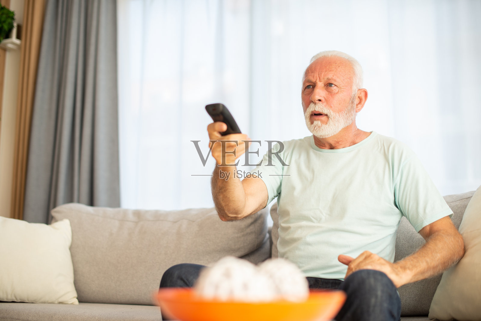 男人在家里享受她最喜欢的电视节目照片摄影图片
