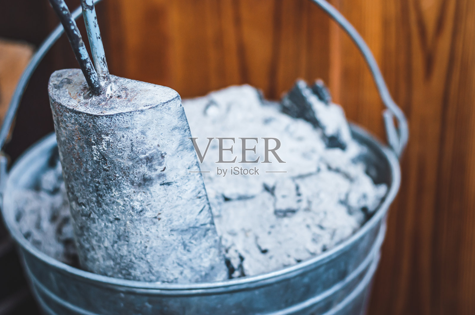 用镀锌铁桶清洗家庭壁炉中的木炭和灰。照片摄影图片