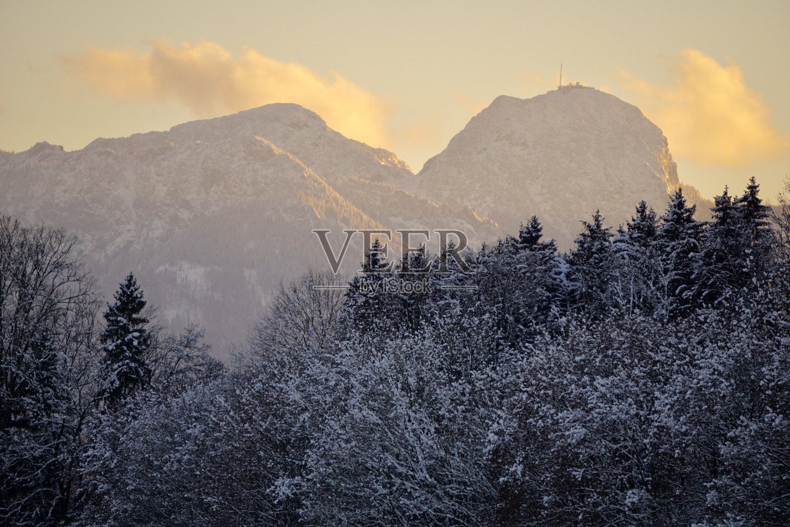 冬季阿尔卑斯山的日落。初冬，阿尔卑斯村庄的日落。巴伐利亚村庄的雾和日落。冬天日落时分的群山。冬天的巴伐利亚村。照片摄影图片
