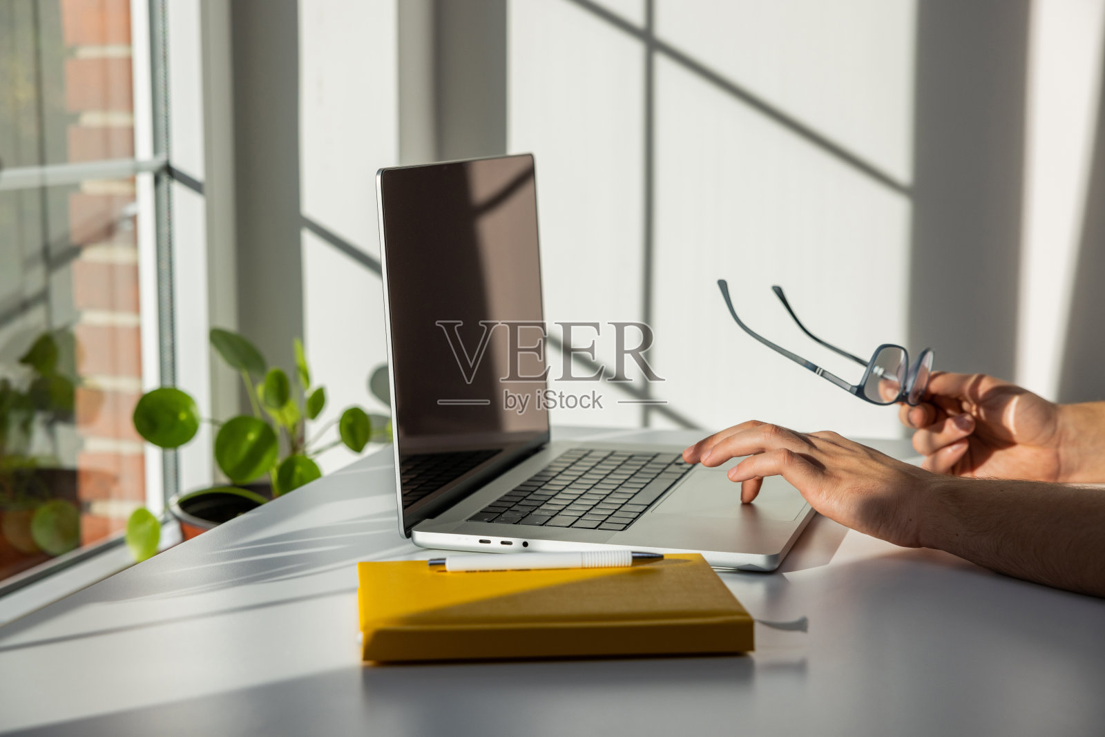 侧视图，一个面目全非的少年正在用笔记本电脑照片摄影图片