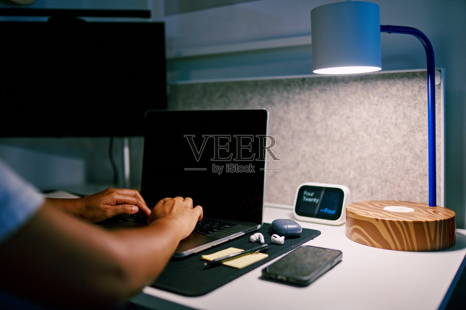 近手年轻男子在笔记本电脑上打字在晚上。照片摄影图片