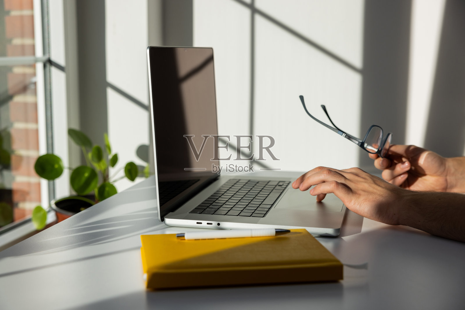 侧视图，一个面目全非的少年正在用笔记本电脑照片摄影图片